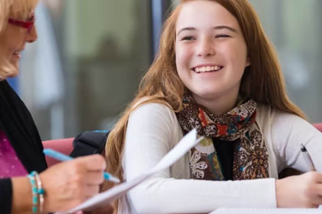 Girl smiling as adult holding paper